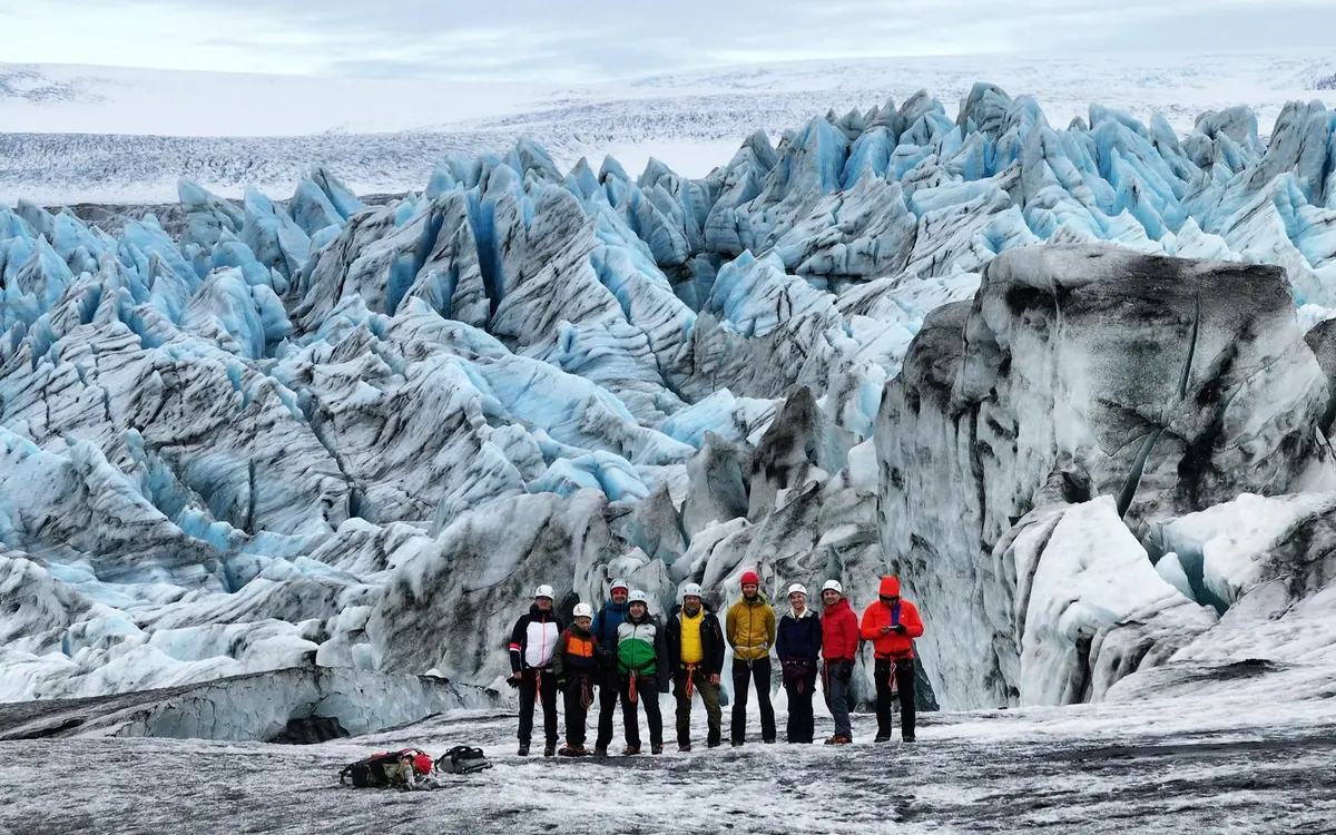 Wanderer mit Steigeisen auf dem blanken Sommereis einer Gletscherzunge bei Skaftafell