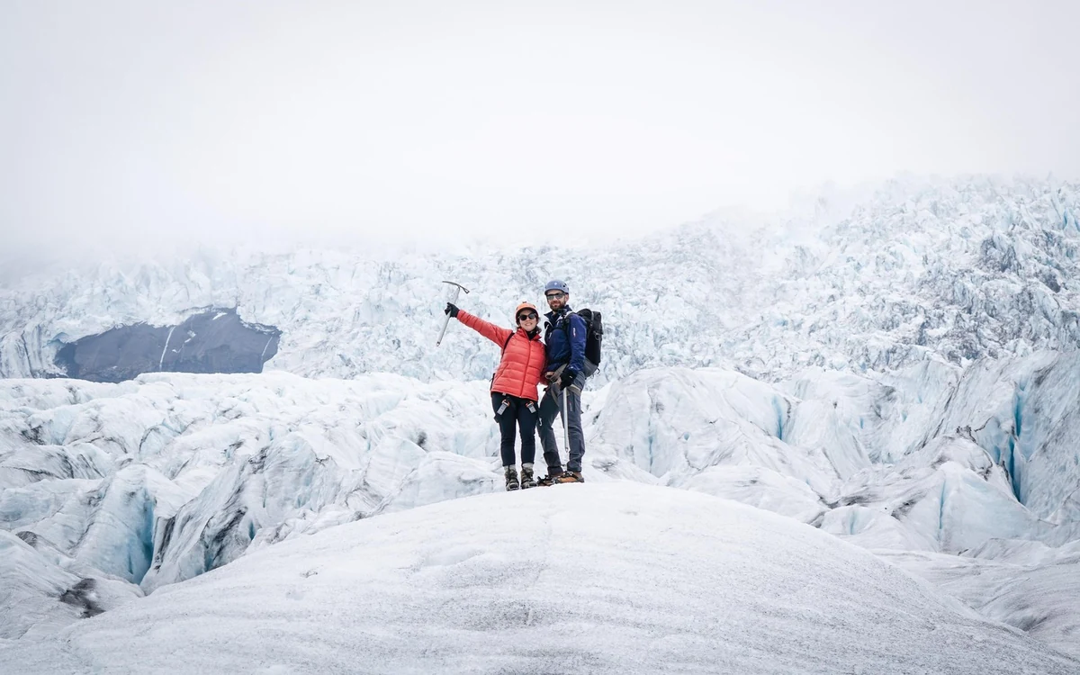 Walkers in crampons crossing the ridged surface of an outlet glacier below the ice cap